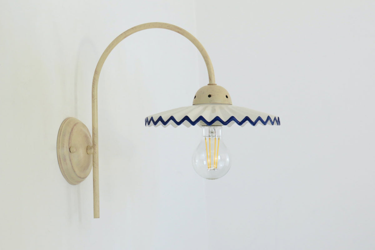 Applique BERENICE con braccio avorio e paralume in ceramica ondulata bordo blu, montata a parete – Diamantlux