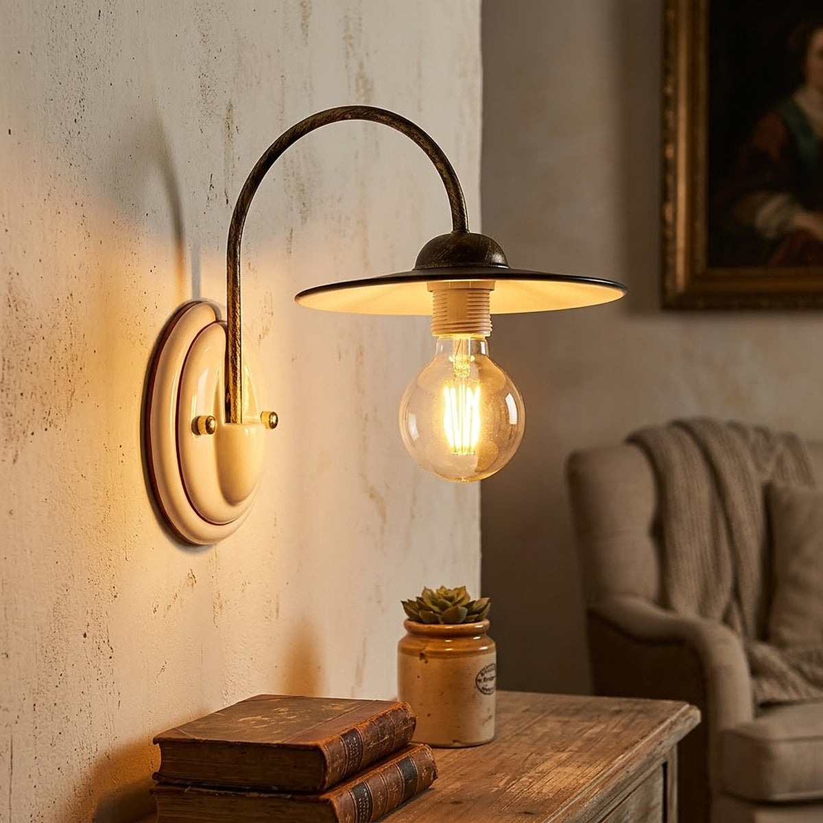 Applique rustica BIBI2-A accesa in un salotto country: base in ceramica bianca con decorazione marrone, braccio in metallo nero oro, luce calda