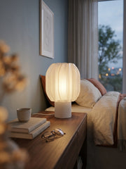 Lampada da tavolo stampata in 3D Petulia accesa su un comodino in camera da letto, luce calda e diffusa – KreoLumo