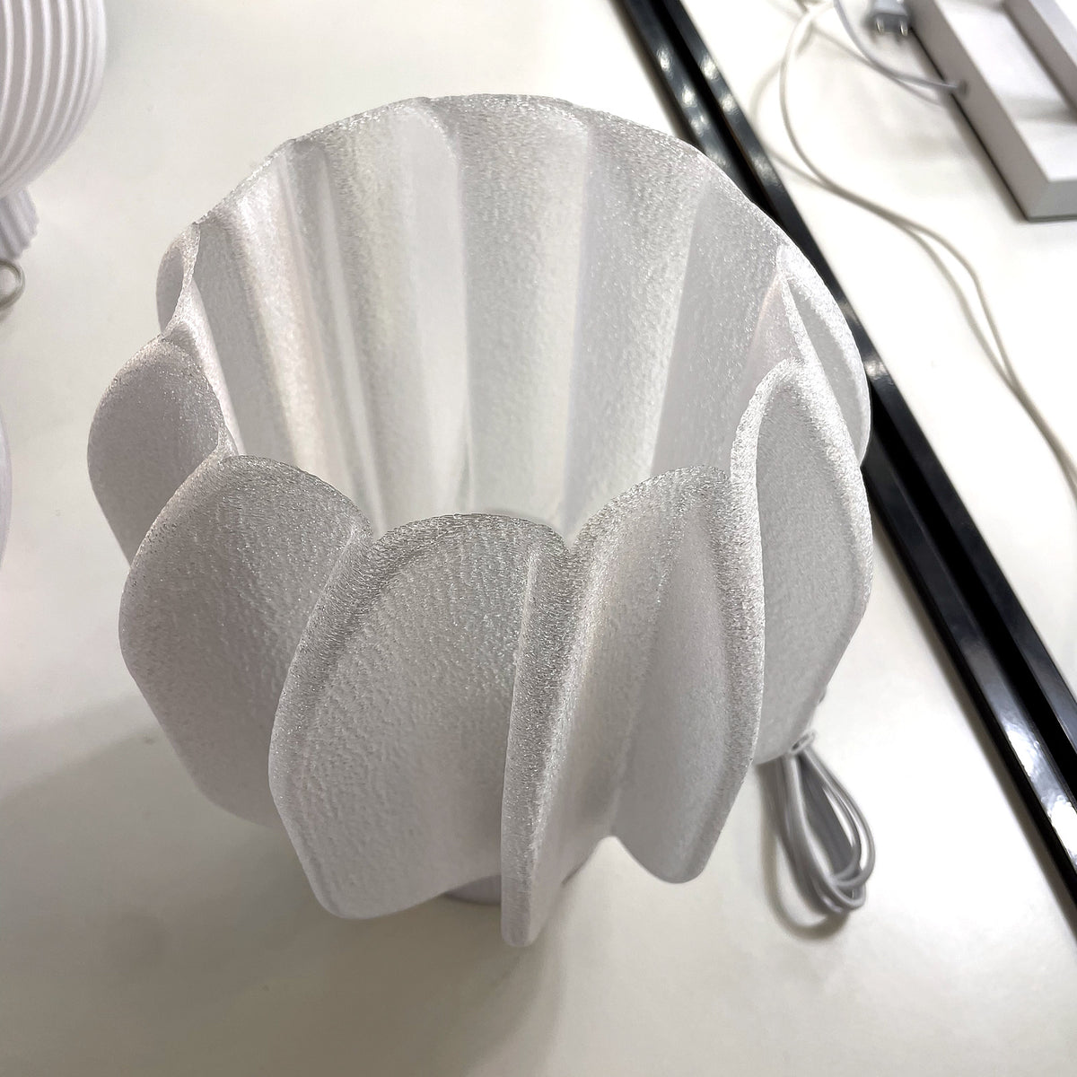 Dettaglio del paralume a petali della lampada da tavolo stampata in 3D Petulia: texture del PETG traslucido – KreoLumo