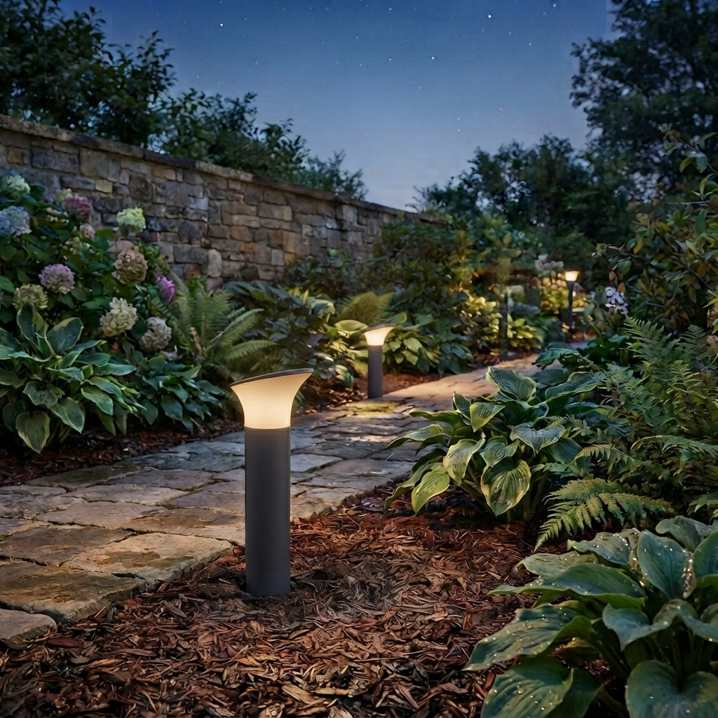 Paletti da giardino Spacelux Metter 30 cm accesi lungo un vialetto in pietra di sera